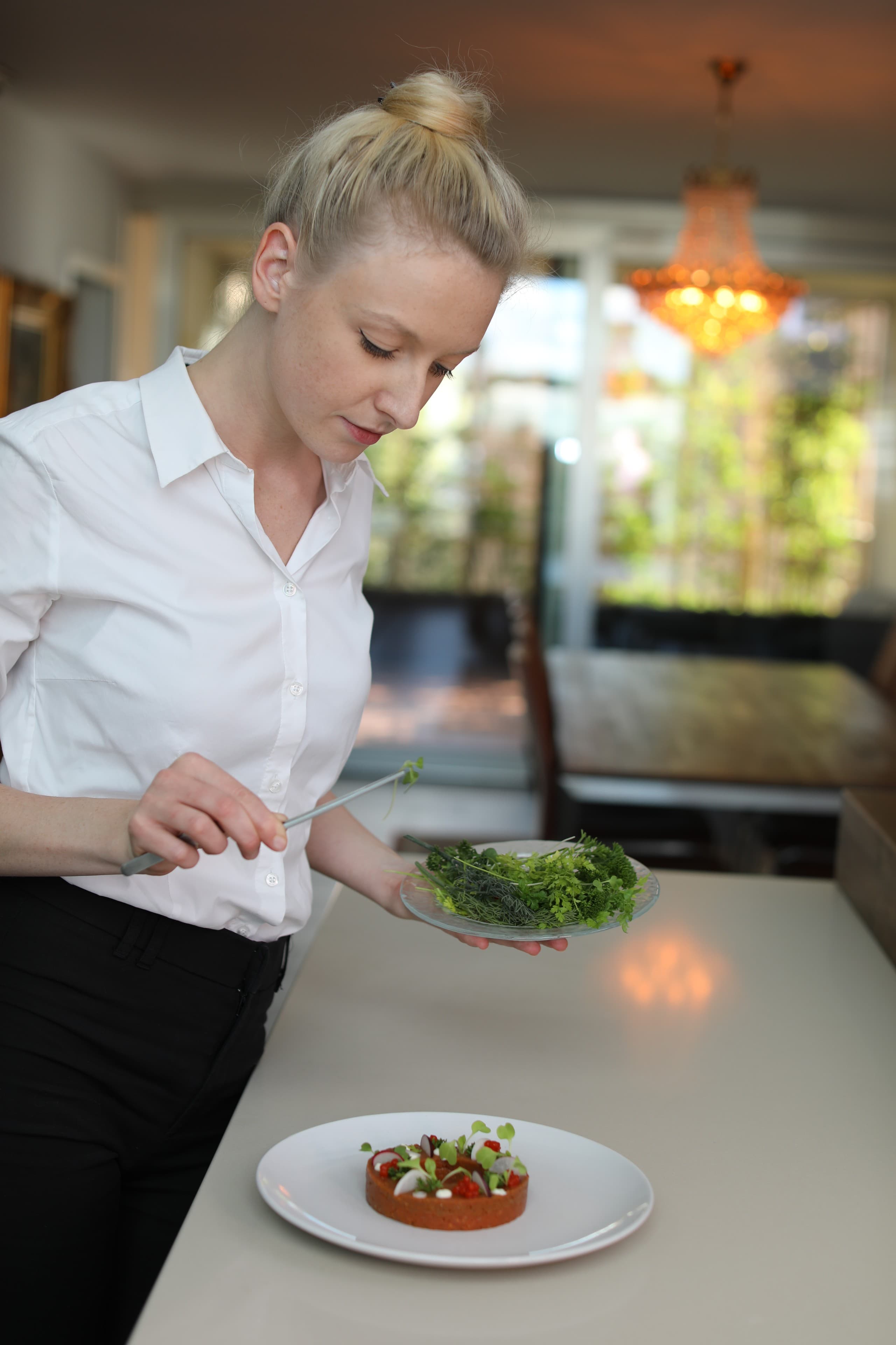 Chef Juliette plating by the window