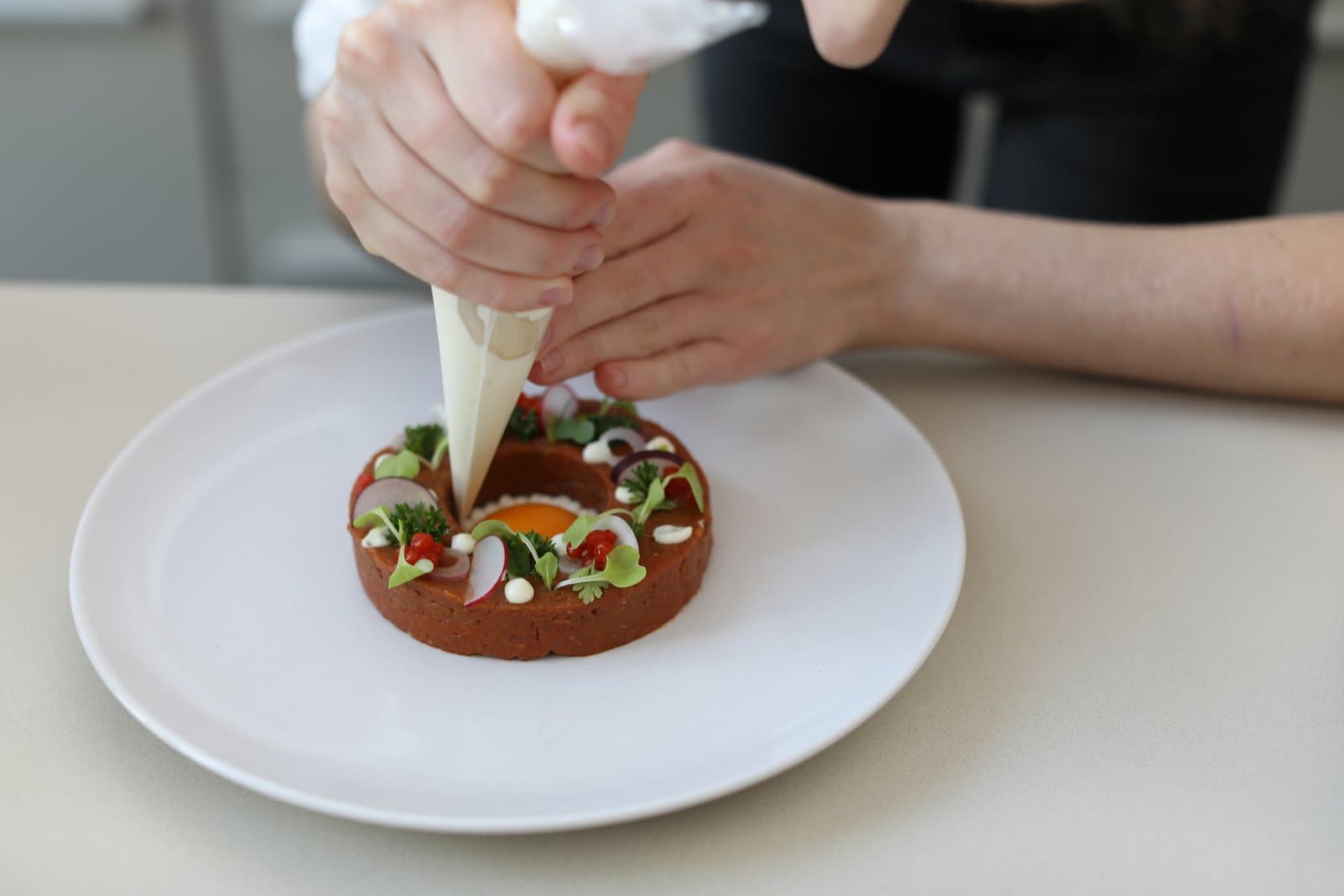 Chef Juliette piping onto a plate